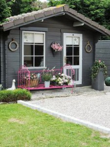 Aménagement d'un abri de jardin avec un banc rose