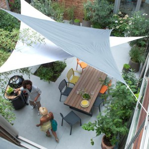 Décorer sa terrasse : Voiles d'ombrage, table en bois et jeu de couleur avec les chaises