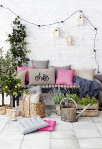 Éléments de déco : Canapé, coussins, plantes, panier, arrosoir, guirlande